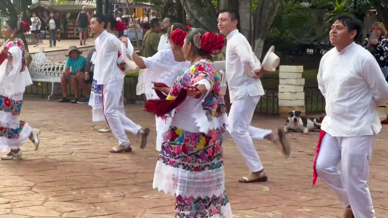 Handheld close-up tracking shot of traditional Mexican dancers performing in Valladolid, Mexico. 4K