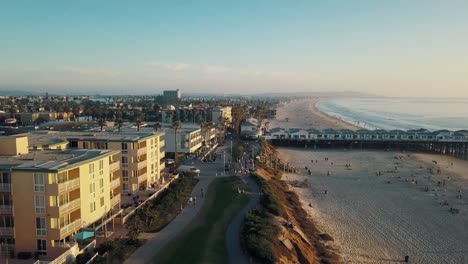 People-walking-outdoors-at-Pacific-Beach-in-California-San-Diego-while-sunset---Aerial-4k-footage---Crystal-Pier