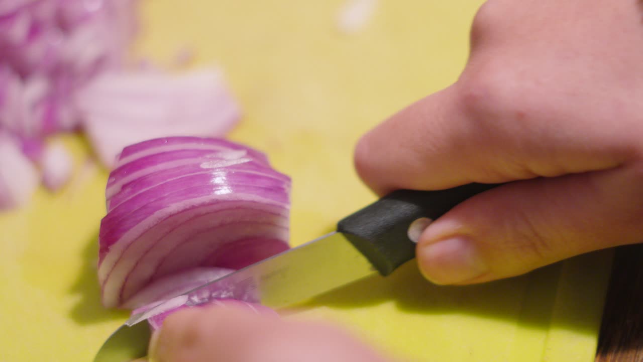 Red Onion Being Sliced on Chopping Board with Small Knife with Pieces in Background. Healthy Organic Food Prep Clip