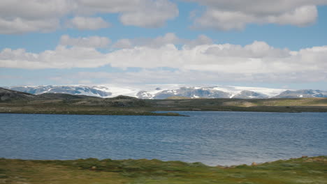 go along the beautiful landscape of norway in the distance you can see mountains and a glacier on to