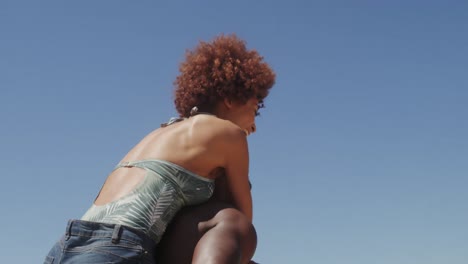 shirtless man giving piggyback ride to woman at beach 4k