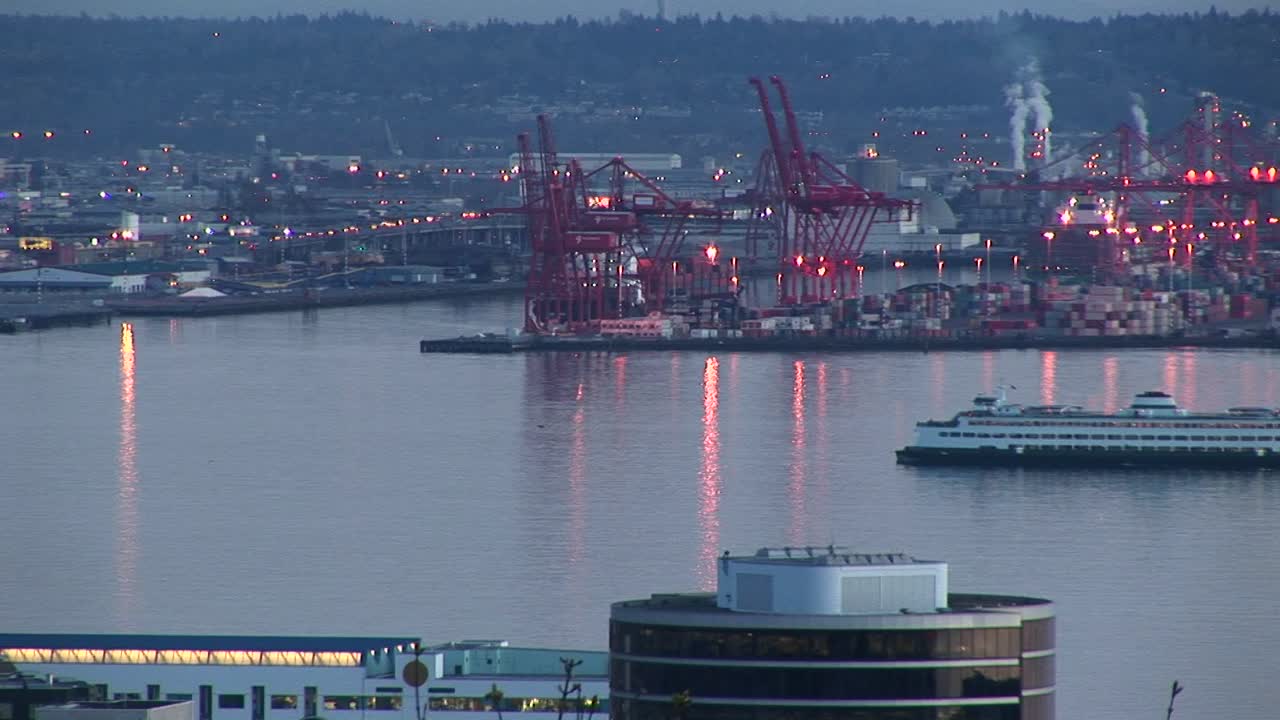 유람선은 골든 아워에 시애틀의 분주한 항구를 천천히 통과합니다.