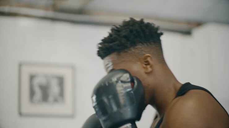 Primo Piano Medio di Pugile che Colpisce il Sacco da Boxe