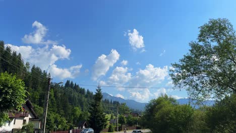 sunny rural mountain landscape with blue sky and white clouds