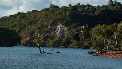 Gramame-river-beach-with-beautiful-tropical-water-and-sand-surrounded-by-exotic-green-foliage-and-cliffs-perfect-for-locals-to-bath-and-relax-near-the-capital-city-of-Joao-Pessoa-in-Paraiba,-Brazil