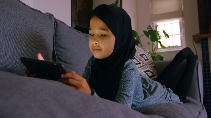 Ragazza con l'hijab che usa un tablet in salotto 4k