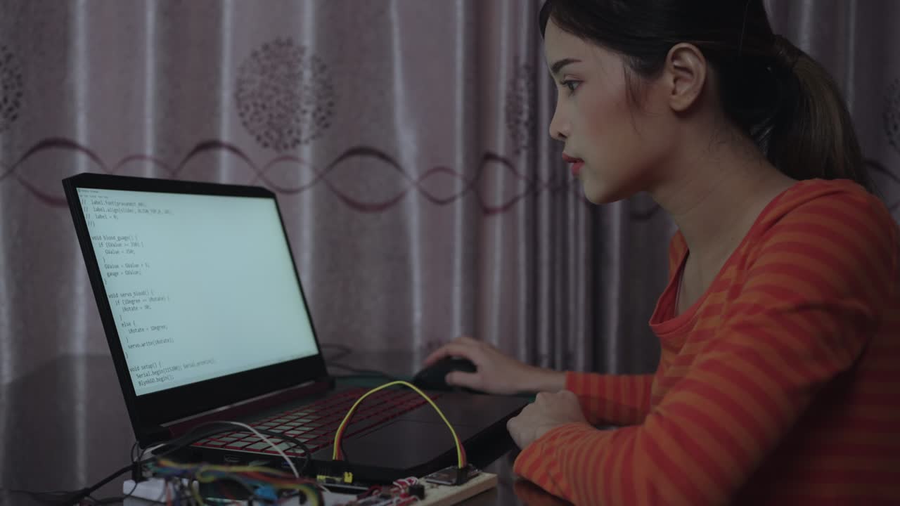 Technician Asian woman assembles electronic circuits with a microcontroller board open-source hardware and software