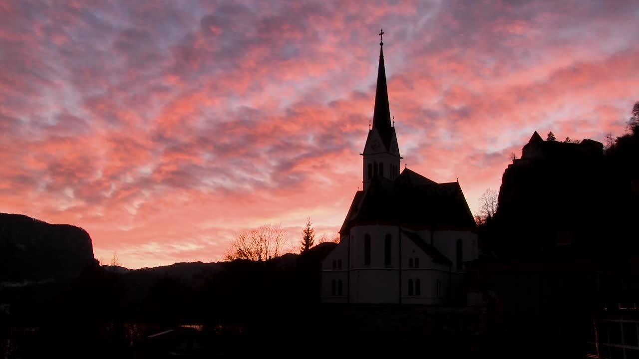 찬란한 하늘을 배경으로 한 교회가 실루엣을 이루고 있다