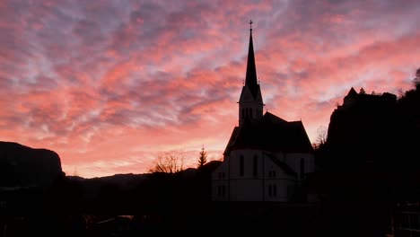 A-church-is-silhouetted-against-a-brilliant-sky