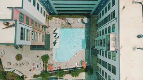 unique drone footage of a slow push into the pool and patio area of an apartment complex