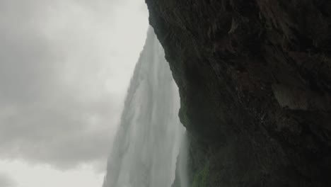 Tilt-up-from-behind-a-waterfall-in-Iceland