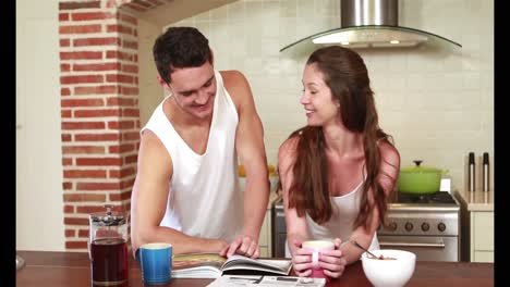 una pareja feliz leyendo el periódico juntos