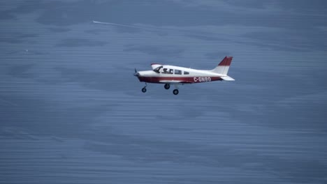 avión piper pa-28 cherokee volando sobre el mar azul, toma aire-aire
