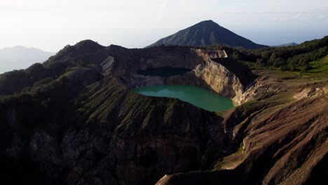 mesmerizing drone footage of kelimutu volcano, capturing the vibrant colors of its crater lakes and the surrounding natural beauty