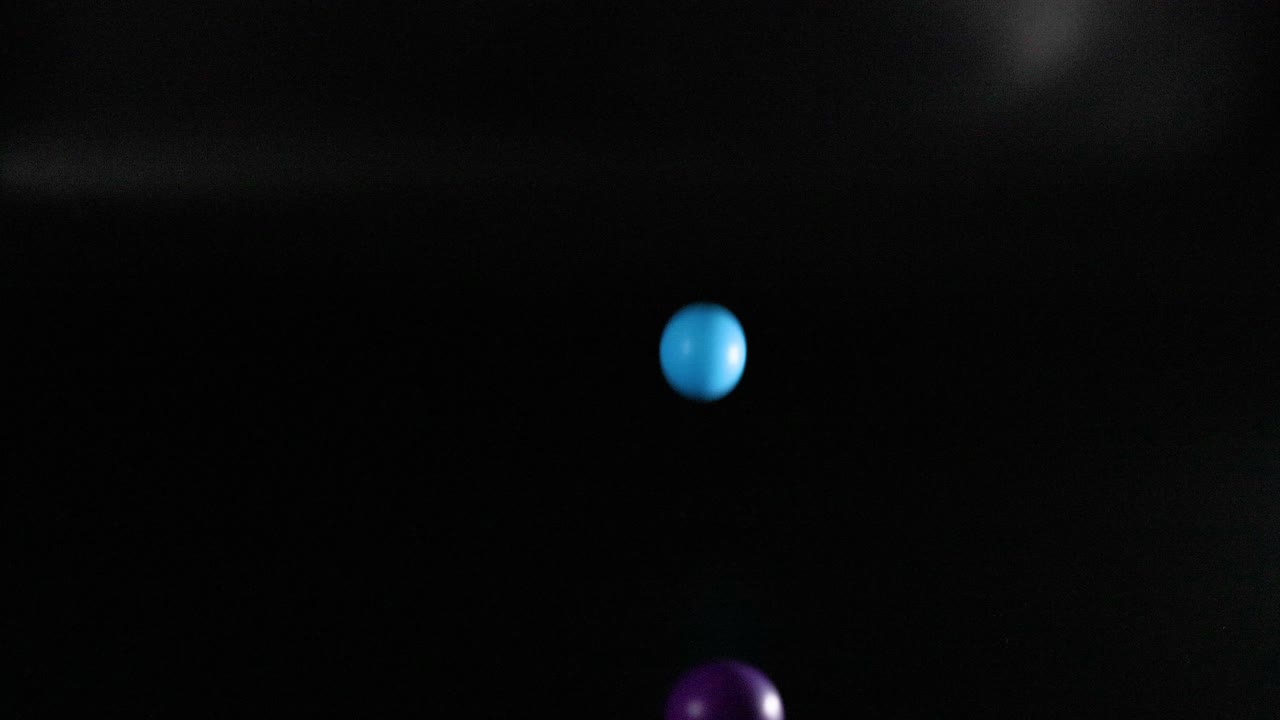 Multiple colored balls bouncing in a dark space