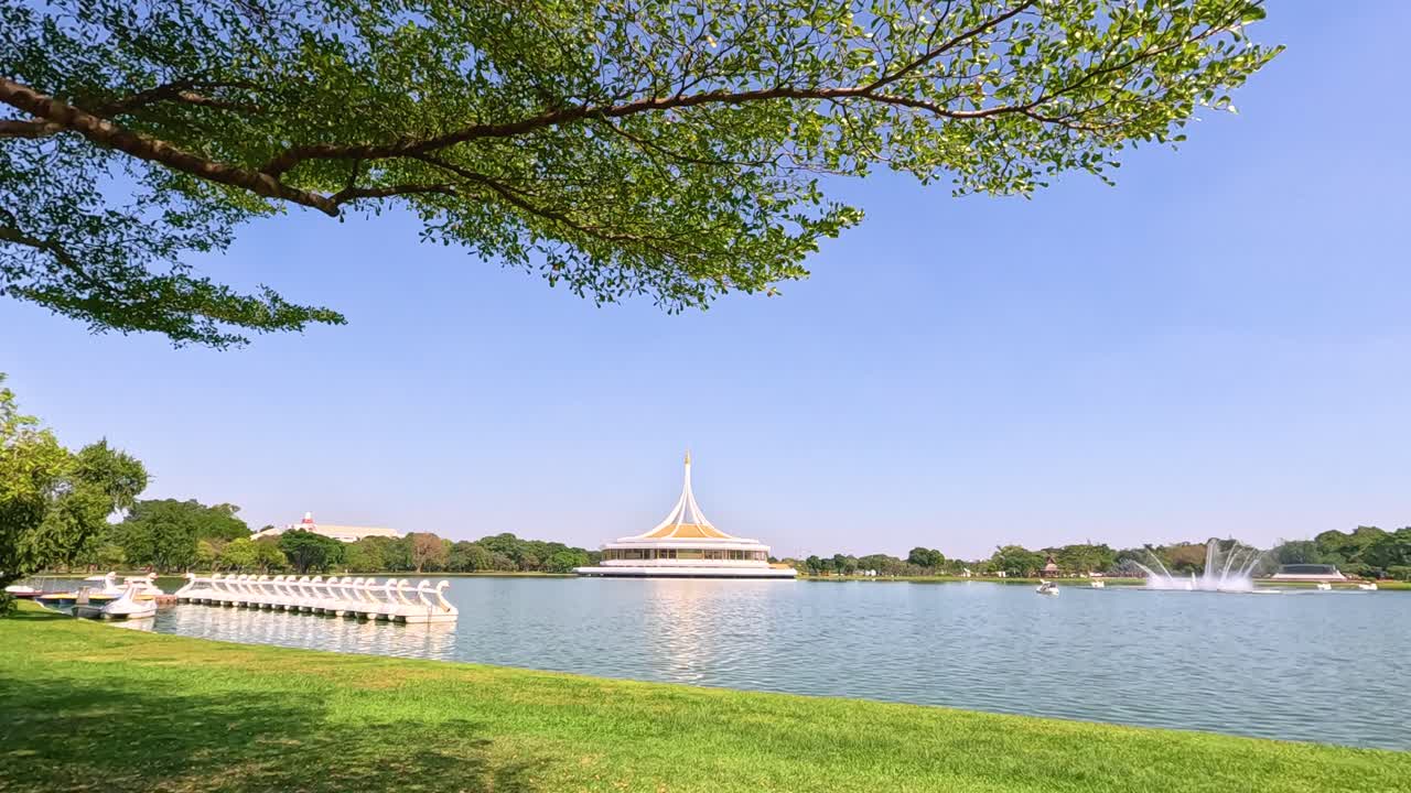 방의 라마 ix 공원 연못의 조용한 장면, 울창한 초록색과 은 파란 하늘, 낮에 포착