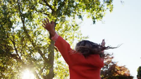 Girl-outdoors-turning-and-holding-up-hands