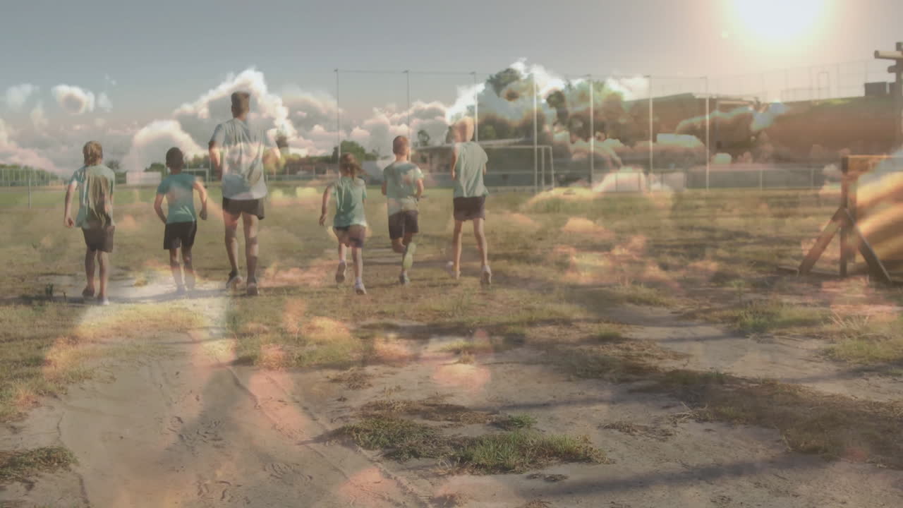 Running on grassy field, children with cloud animation overlay in school setting