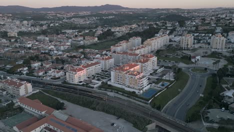 在里斯本的são pedro do estoril,在第一批阳光下,在铁路轨道上的火车上空的无人机视图