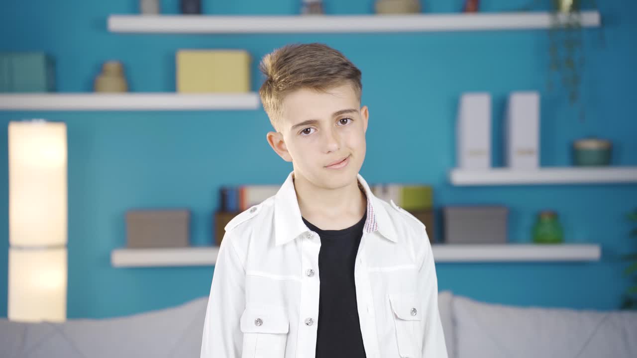 un niño infeliz mirando a la cámara en casa.