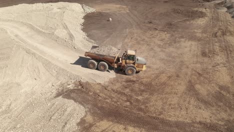 A-bird's-eye-view-of-a-full-dump-truck-traveling-on-a-construction-site