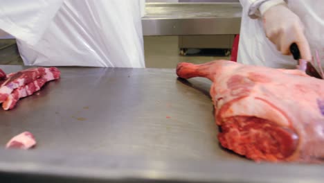 mid section of butchers slicing red meat