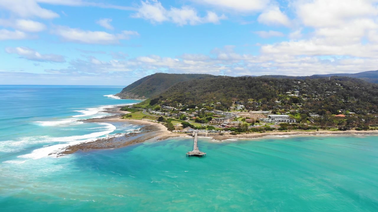 Vue aérienne reculant depuis la jetée au-dessus de l'océan tropical aux eaux turquoise