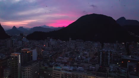 Sobrevuelo-Del-Barrio-De-Copacabana-Y-Morro-De-São-João-Silhouete-Durante-La-Vibrante-Puesta-De-Sol