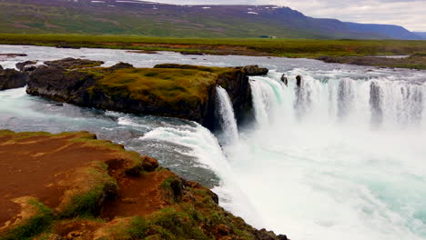 Stunning-Godafoss-Icelandic-horseshoe-waterfall-pan-from-upstream-to-falls-BEST-4k-ProRezHQ-on-river-Skjálfandafljót-in-northern-Iceland