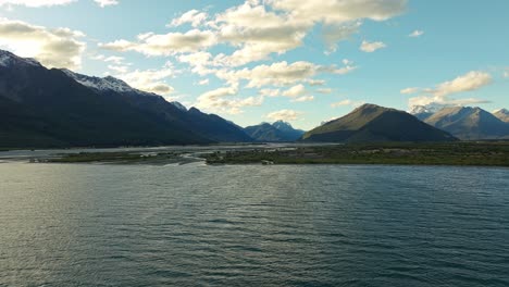 Establecimiento-Aéreo-Panorámico-De-Luz-Dorada-Que-Se-Refleja-A-Través-De-Las-Nubes-Hacia-El-Lago-Wakatipu-Con-Tierras-Bajas-De-Glenorchy-Detrás