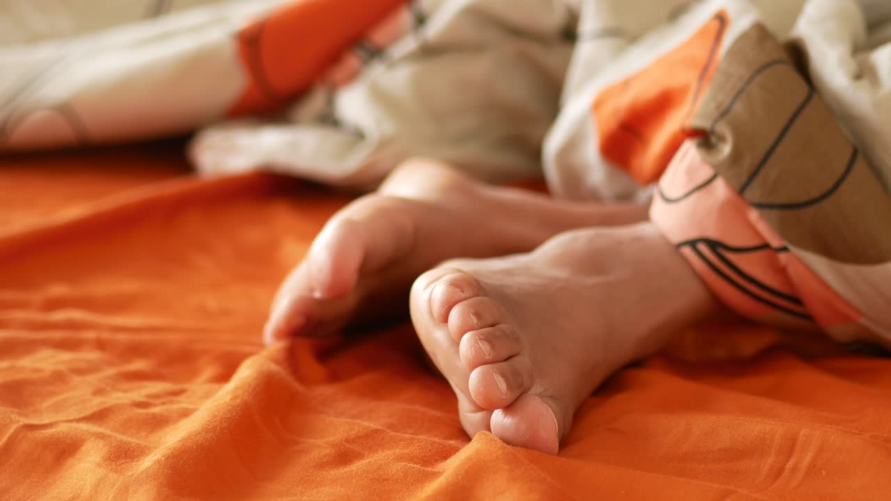 Closeup of a Person's Feet in Bed