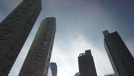 slow moving shot of tall waterfront buildings towering in the sky