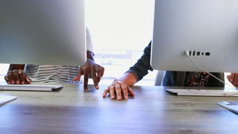 Executives-holding-hands-while-working-at-desk-4k