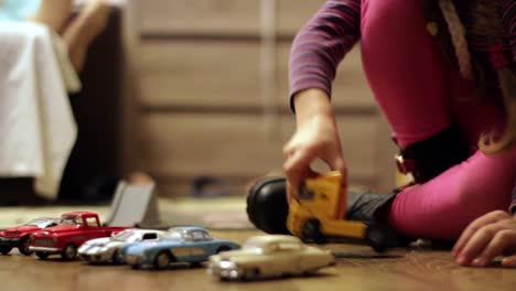 child girl plays with a yellow truck toy car