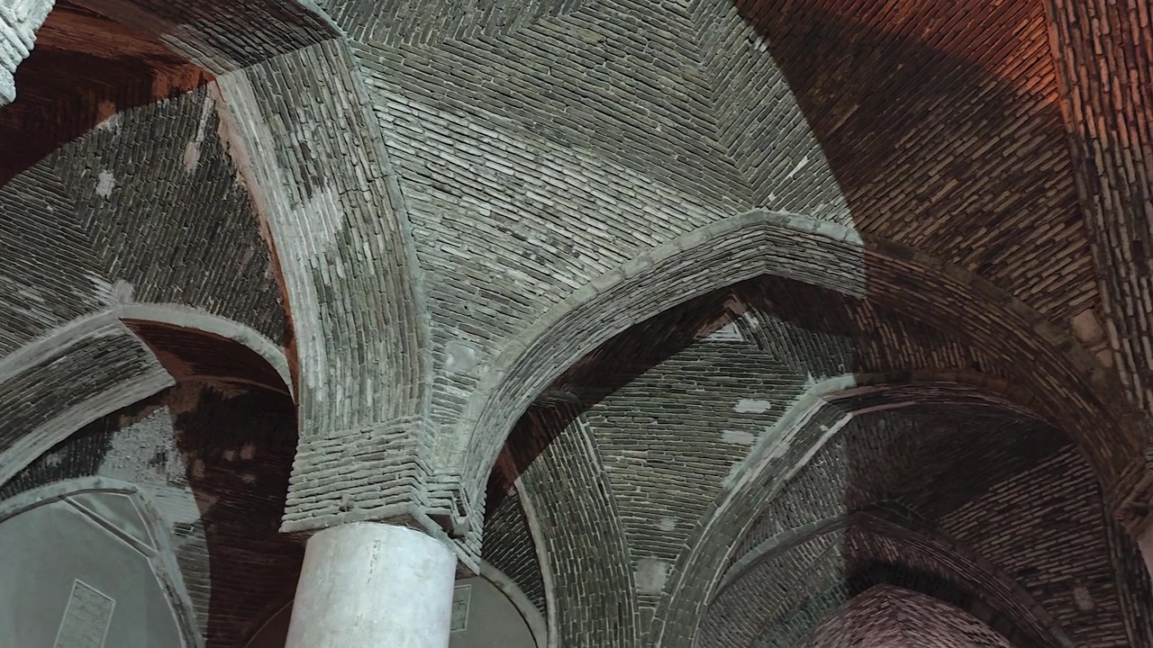 Pohled zdola na starobylý cihlový klenutý strop v historické budově