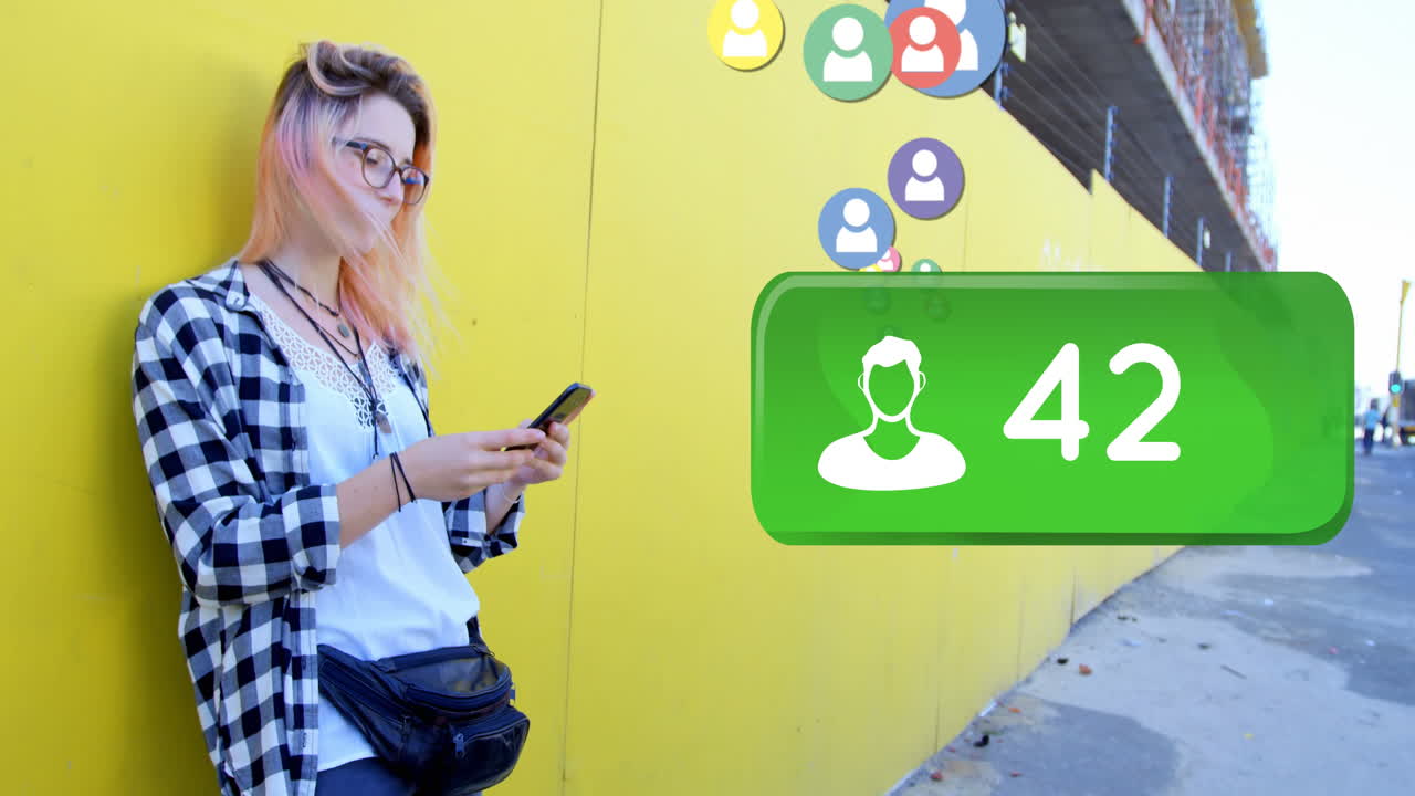 mujer apoyada en una pared amarilla navegando en su teléfono 4k