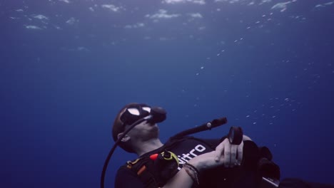a person scuba diving underwater in blue ocean water
