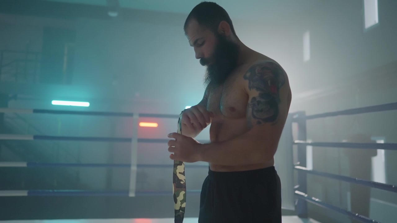 Bearded Boxer Prepares for Fight by Wrapping Hands in Ring