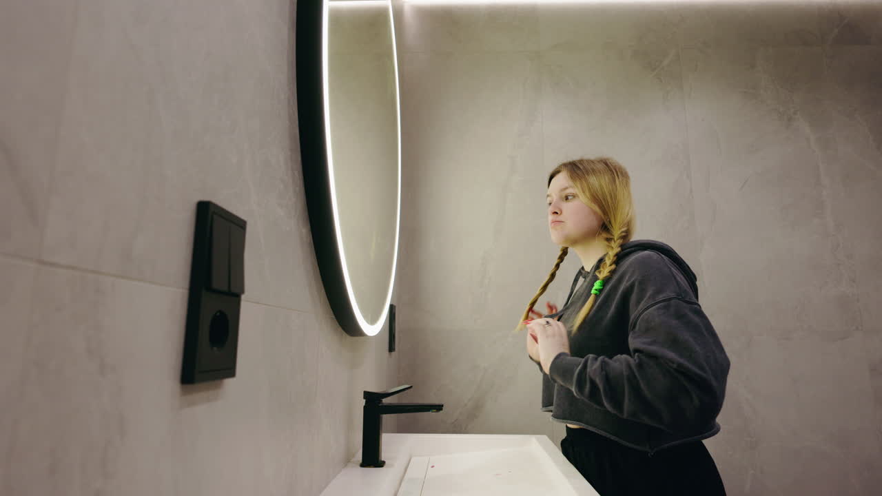 Woman Styling Hair in Modern Bathroom