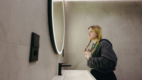 woman styling hair in modern bathroom
