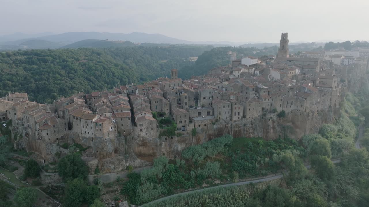 Aerial Drone view of the hilltop Medieval town of Pitigliano, Tuscany and the Valdorcia in morning light, flying over old buildings and rooftops, in 4K