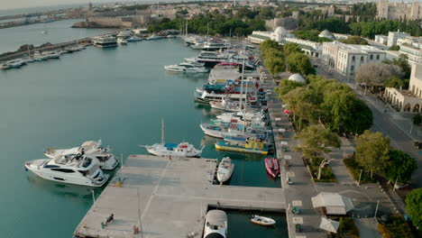 an aerial city view of rhodes island in greece containing clips of the medieval old town, the old lighthouse at the port, old windmills, beaches and amazing sunset