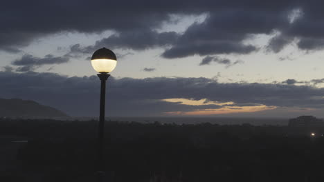 A-timelapse-of-a-street-lamp-turning-off-as-dawn-breaks-in-a-coastal-town