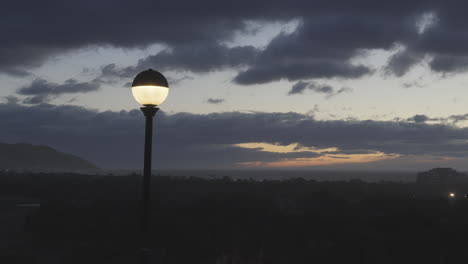 a timelapse of a street lamp turning off as dawn breaks in a coastal town