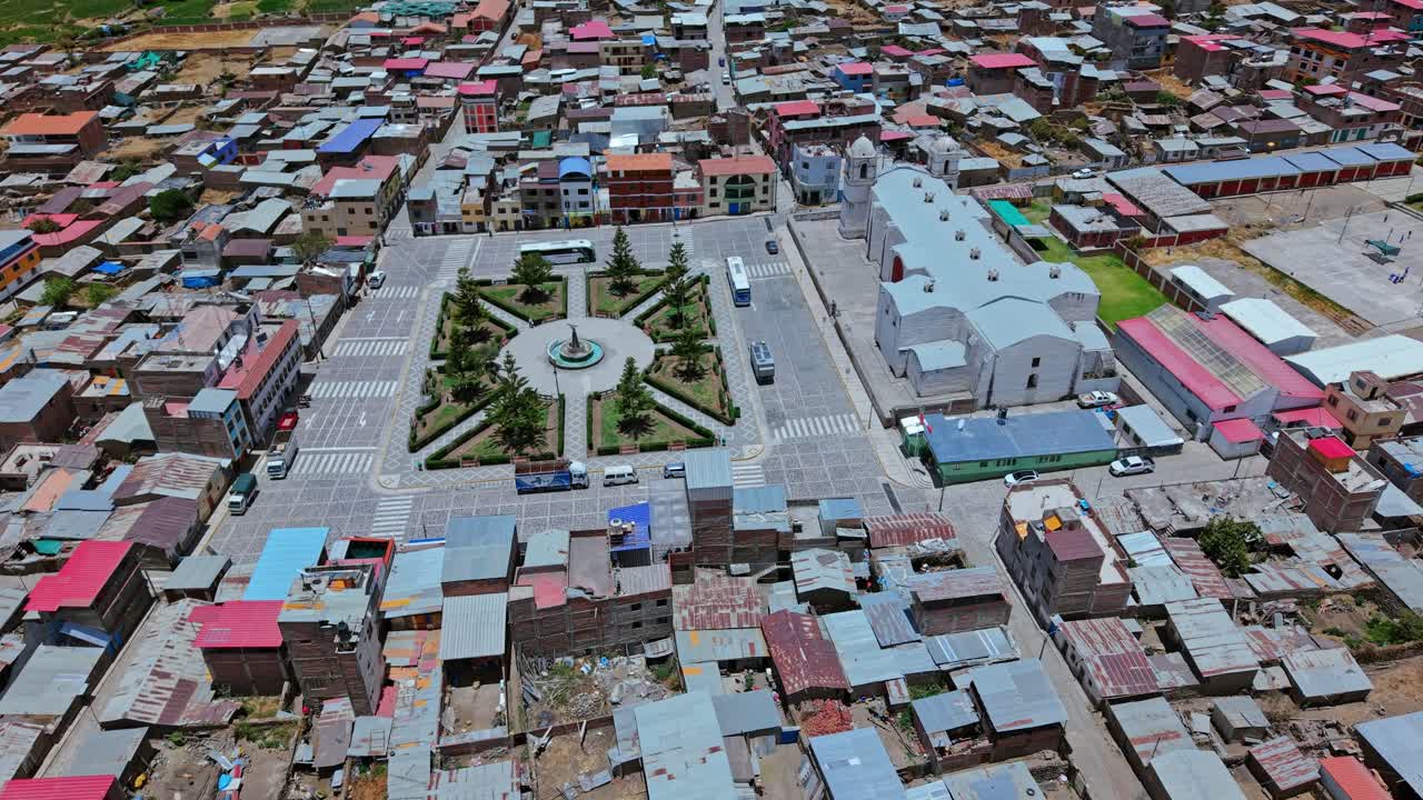 Drone melakukan penurunan corkscrew langsung ke plaza pusat Cabanaconde, Peru. Rekaman menyoroti tata letak desa pedesaan, jalanan, dan area pertemuan pusat dalam gaya sinematik imersif