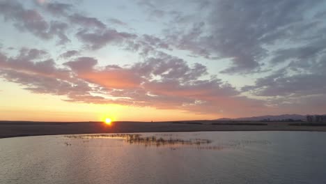 sunrise over a lake with mountains in the background