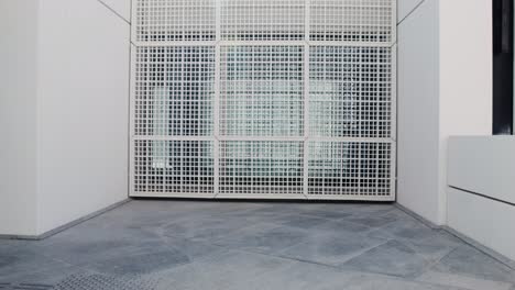 exterior building detail with white metal grids and grey tile flooring