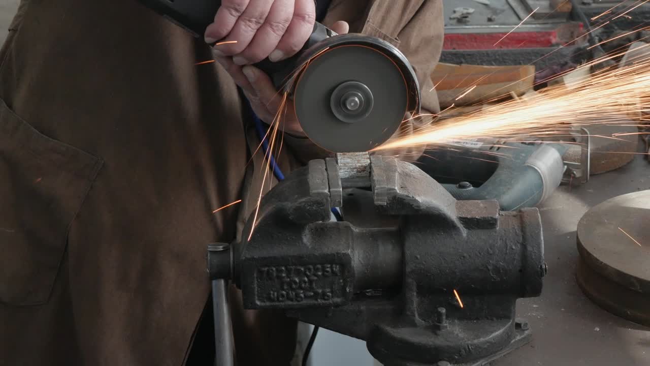 искры во время резки металла угловой шлифовальной машиной. рабочий отрезает металлический угол.