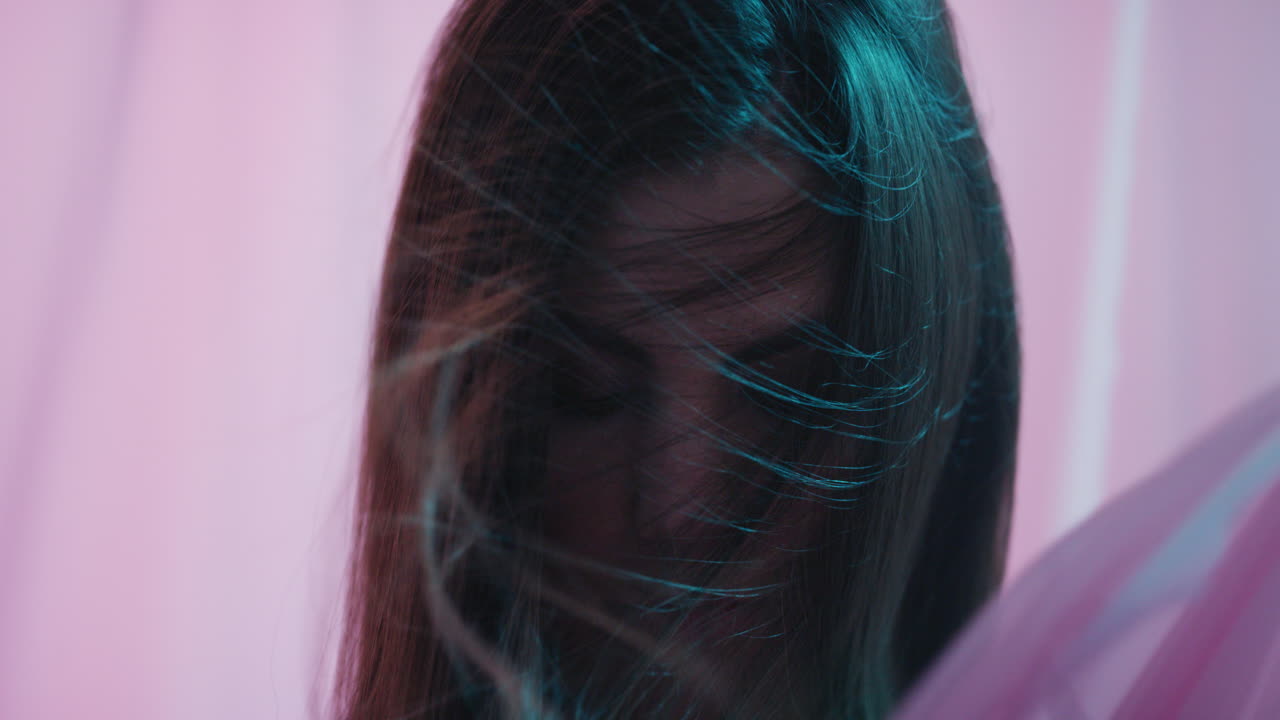 다채로운 판타지 아름다운 젊은 여성은 시트 사이에 매혹적으로 보입니다 감각적인 여성적인 아름다움 커튼이 다채로운 배경에서 불고 있습니다.