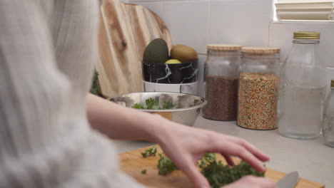 manos poniendo verduras en una ensaladera después de cortar comida vegana saludable y dieta para bajar de peso